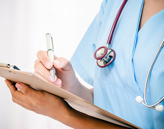 Nurse writing notes on clipboard