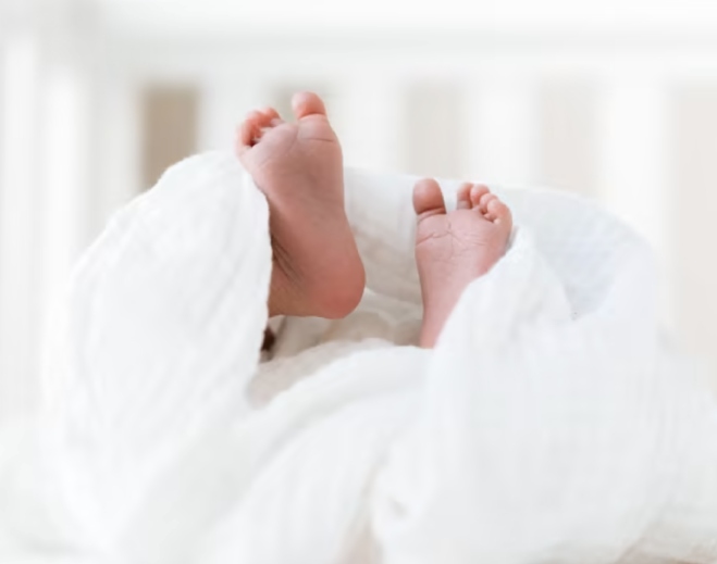 Newborn baby feet under blanket