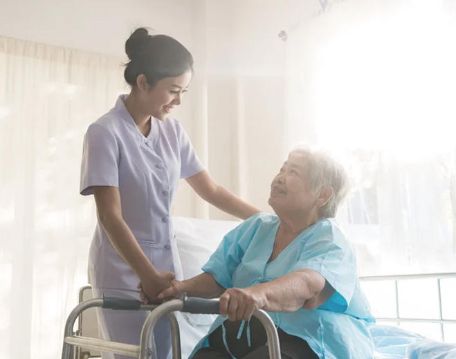 Nurse assisting elderly patient with walker