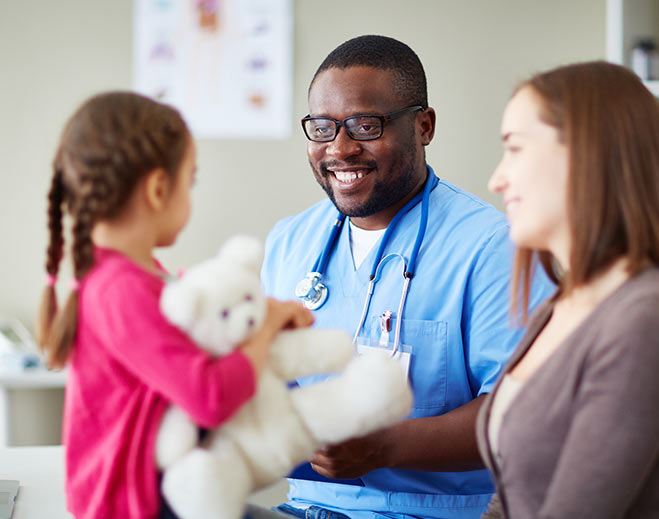 Pediatric doctor giving child teddy bear