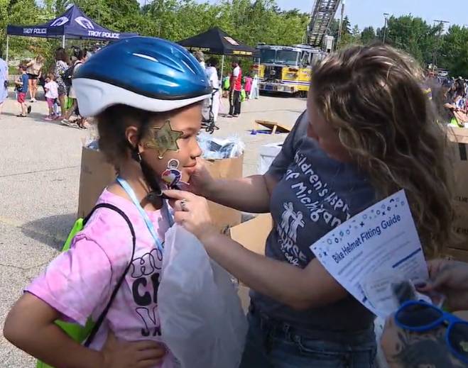 Child receiving bicycle helmet fitting