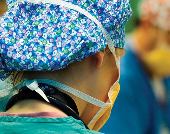 Surgeon wearing scrubs and face mask