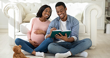 Couple reviewing baby plans with notebook
