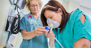 Patient using nebulizer under nurse guidance