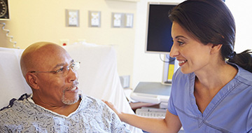 Nurse talking with patient in hospital bed