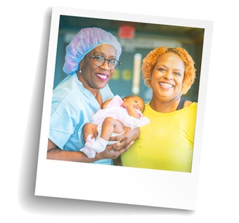 Adult holding newborn with nurse