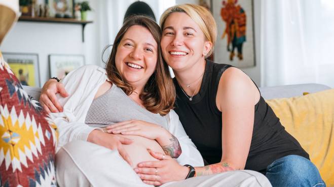 Couple sitting with pregnant person at home
