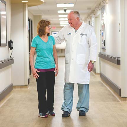 Orthopedic surgeon walking with patient