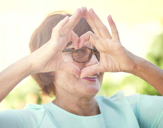 woman making shape of heart with her hands